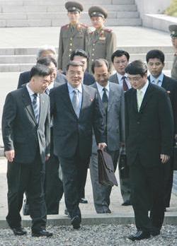 North Korea's Deputy Director-General for Ministry of Foreign Affairs Hyon Hak-bong (second from left) crosses the border line for a meeting with South Korea's Director General for North Korean Nuclear Bureau of Foreign Ministry, Hwang Joon-kook, at Panmunjom, South Korea, yesterday.