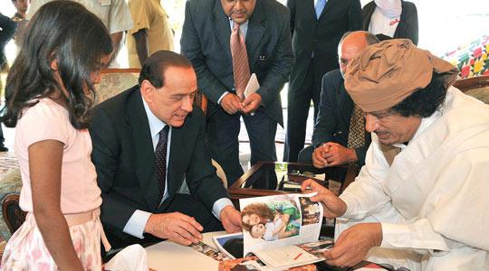 Prime Minister Silvio Berlusconi exchanges gifts with Libya's leader Muammar Gaddafi in Benghazi.