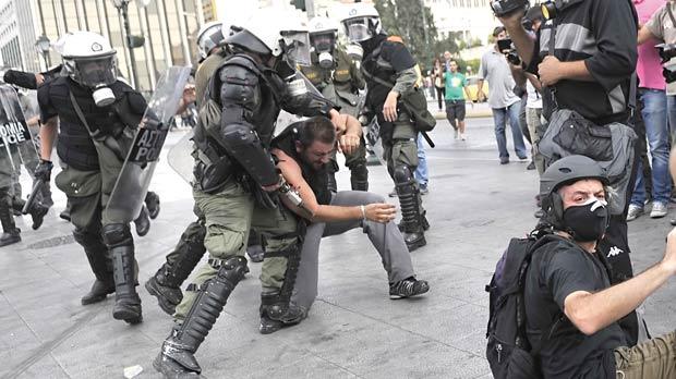 Police detain a demonstrator during a protest rally marking the 24-hours general strike yesterday. More than 30,000 public sector workers demonstrated in Greece in a strike against deeper austerity cuts that shut down courts, schools and transport, including air traffic. Photo: Louisa Gouliamaki/AFP